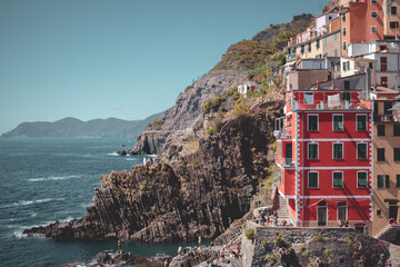 Fototapeta na wymiar View on the colorful houses and the sea along the coastline of Cinque Terre area in Riomaggiore