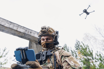 Military soldier controls drone for reconnaissance operation of enemy positions. Concept using...