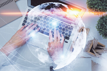 Double exposure of woman hands working on computer and financial theme hologram drawing. Top View. Business concept.