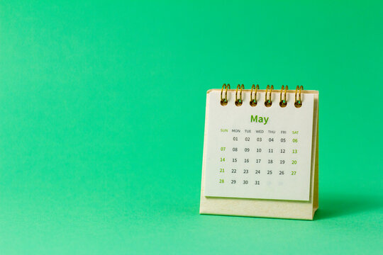 Desktop calendar for May 2023 on a green background.