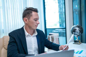 Fototapeta premium Businessman looking at a computer monitor during his working day in the office. Business and success concept