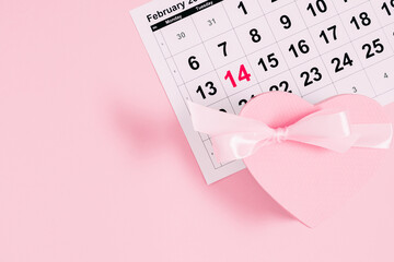 Valentine's Day calendar. Date February 14 on calendar 2023, present, heart shaped gift box on pink background. Valentines Day. Flat lay, top view, copy space 