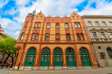 Front view the facade of beautiful old building with old sculptures in the city center of Szeged, Hungary	