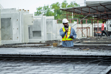 Male engineers are inspecting and controlling the work of the employees and the quality of the manufactured products to meet the standards In industrial factories producing precast prefabricated walls