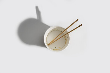 Empty paper bowl with chinese stick on white background.Top view, flay lay