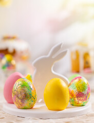 Easter composition with colorful Easter eggs on rabbit dessert plate. Traditional Easter treat