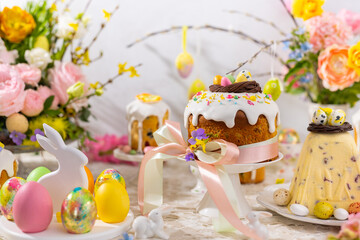 Festive Easter table setting. Easter cake, Easter Eggs, Flower arrangements and home decorations for holiday. - Powered by Adobe