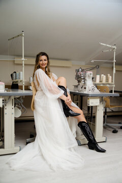 A girl in a boho wedding dress in a sewing workshop.
