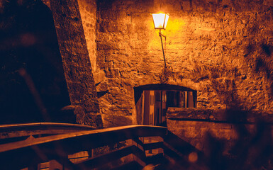 Step back in time to a medieval atmosphere with a wooden bridge leading to a castle entrance, lit...