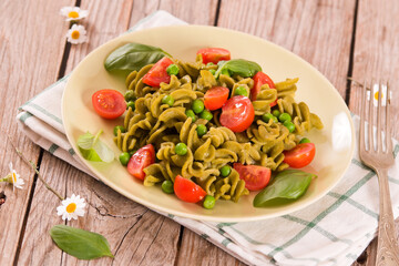 Fusilli pasta with cherry tomatoes and peas.