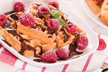 Waffles with raspberries and chocolate cream.