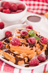 Waffles with raspberries and chocolate cream.