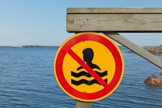 No swimming sign attached to pier on the island of Rövaren, Espoo, Finland.