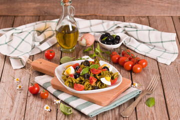 Fusilli pasta with cherry tomatoes, eggs and black olives.