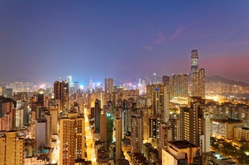 Scenery of Hong Kong viewed from Mong Kok in Kowloon area, with a city skyline of crowded skyscrapers along Victoria Harbour & a brilliant cityscape of street lights glistening in twilight before dawn