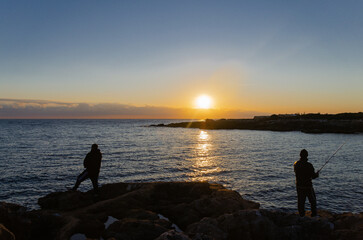 Chicos pescando al atardecer 