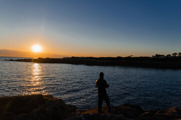 Chico pescando al atardecer 