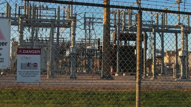 Electrical grid substation and high voltage electric switchyard converter transformer in America. Power station with pylons and distribution cables for city households and EV charging stations.