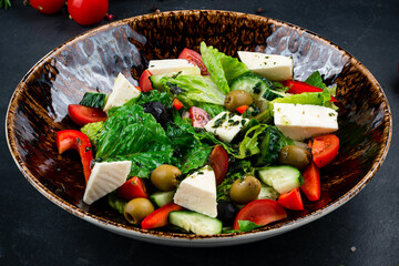 Classic greek salad of fresh cucumber, tomato, sweet pepper, lettuce, red onion, feta cheese, olives, spices and olive oil.