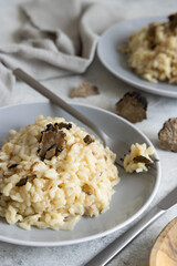 Risotto with porcini mushrooms and black truffles served in a plate top view, gourmet cousine