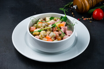 Salad Olivier from boiled vegetables potatoes, carrots and onions, green peas, sausage, mayonnaise .