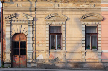 Fototapeta na wymiar vintage door and windows on the grunge facade. abandoned architecture exterior