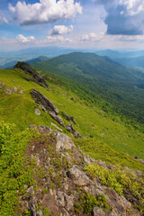 summer mountain landscape. rocks on the grassy hills. beautiful scenery on a sunny day