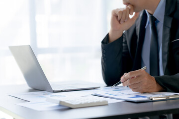 Business man pointing to expense chart image for the allocation of the company's next year's revenue budget in the office.