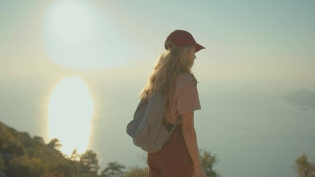 Close-up portrait of child traveler with backpack. School-age girl hiking in mountains