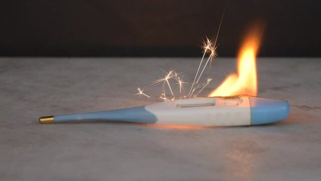 The battery has ignited in the electronic thermometer, fire, flame and sparks are burning. Short circuit, poor battery contact,
