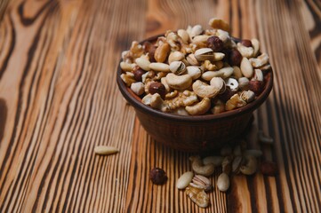 mixed nuts in a bowl on wooden table, top view with copy space.
