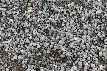 Gray raw rocks and rough stones as natural stones background with crushed and rough material as building material or rocky base for concrete mixture in gray colors as natural stones background