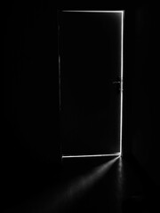 A dark door with a light behind it, light in the dark through an open door