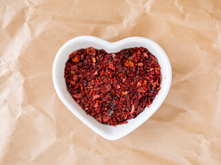 Dried red paprika slices in a heart shaped white bowl