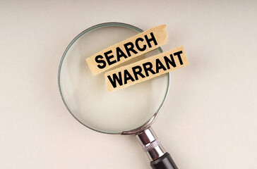 On the magnifying glass are paper strips with the inscription - Search Warrant