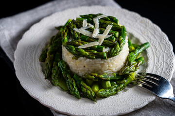 Asparagus risotto garnished with additional spears of asparagus and parmesan cheese. 