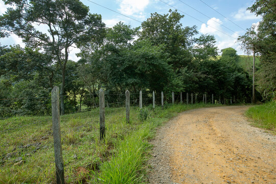 dirt road with wooden fence and barbed wire in countryside of Sao Paulo state, Brazil