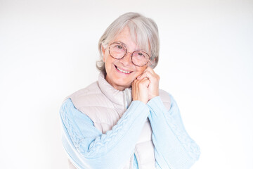 Close-up portrait of smiling white-haired senior woman touching her face with hands. Attractive mature lady in good mood isolated on white background