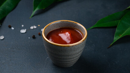 Ketchup sauce with spices in a small ceramic bowl.