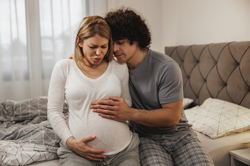 Man Consoling His Pregnant Wife Who Is Having A Contractions