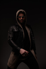 mysterious young man with glasses wearing wool cardigan and leather jacket