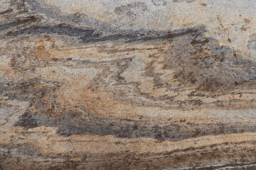 Gold brown and grey stone patterns with stripes from riverbed of Vale Verzasca in Switzerland