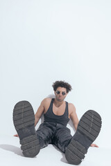 sexy lebanese man with curly hair in leather pants with undershirt sitting