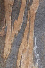 Gold brown and grey stone patterns with stripes from riverbed of Vale Verzasca in Switzerland
