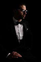 portrait of sexy young man in tuxedo looking to side