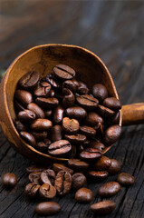 coffee beans with wooden ladle ,on old a wooden background