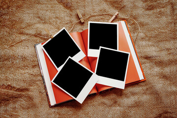Four polaroid cards lie on a mockup book against a background of burlap