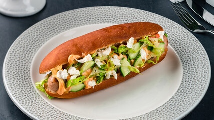 Hot dog with sausage, cucumber, lettuce and cheese.