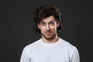 Obraz premium young bearded man in casual white t-shirt looking at the camera