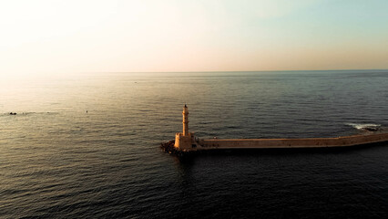 Greek Island Sunset: A Beautiful Aerial View of a Lighthouse Amidst the Twilight Glow